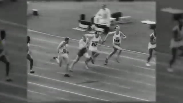 Black-and-white archive footage of sprinters racing down a cinder track in front of a stadium crowd