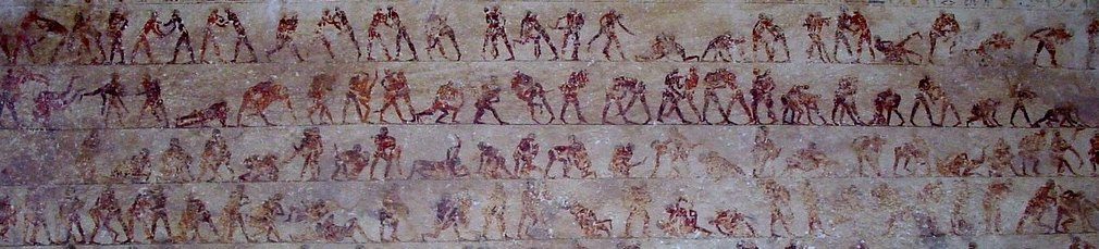 Detail of the wall painting in tomb 15 at Beni Hasan: a row of wrestling pairs, one wrestler painted red and the other dark, grappling in different holds